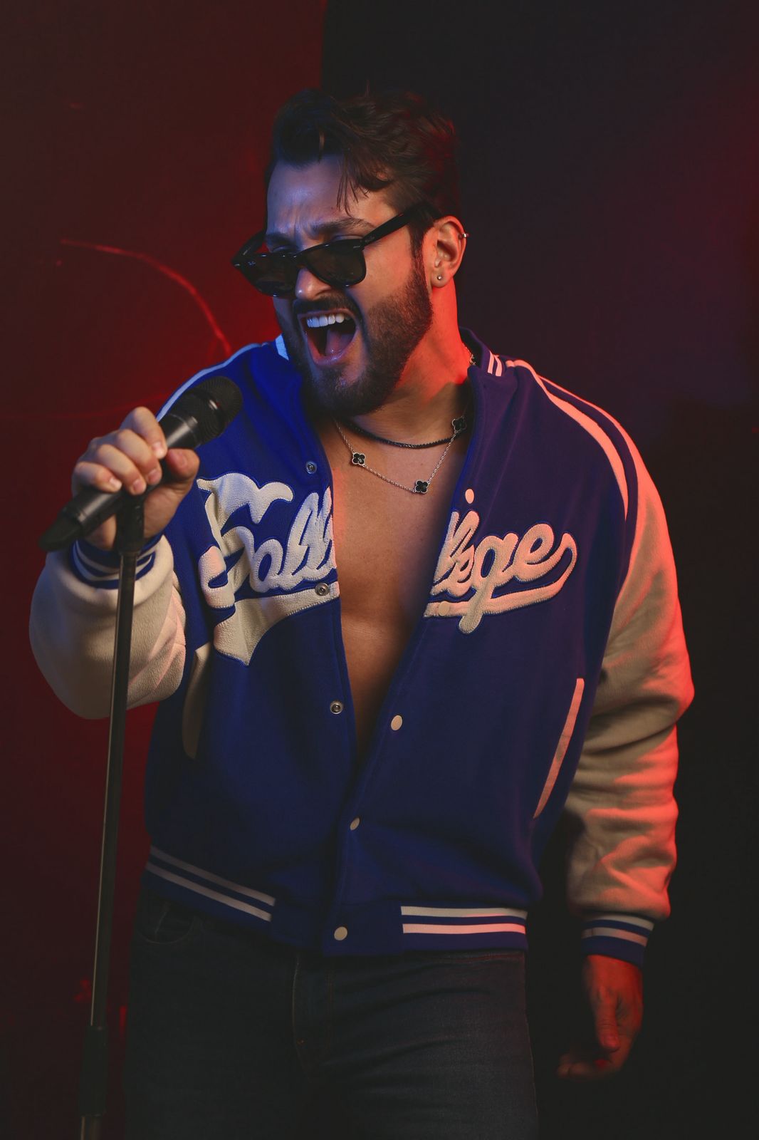 Seu Moço cantando ao vivo no palco sob luz vermelha